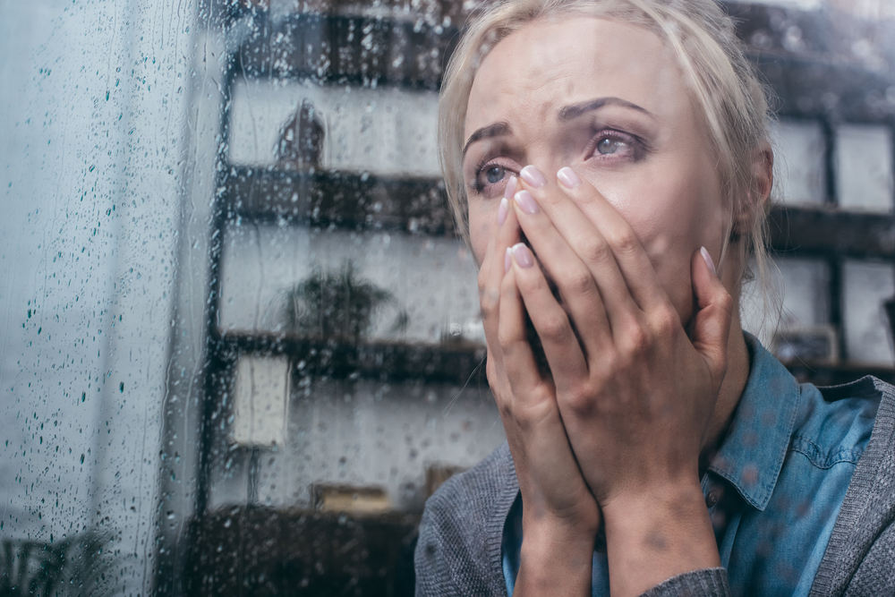 Sad adult woman crying and covering face with hands, Anxiety concept