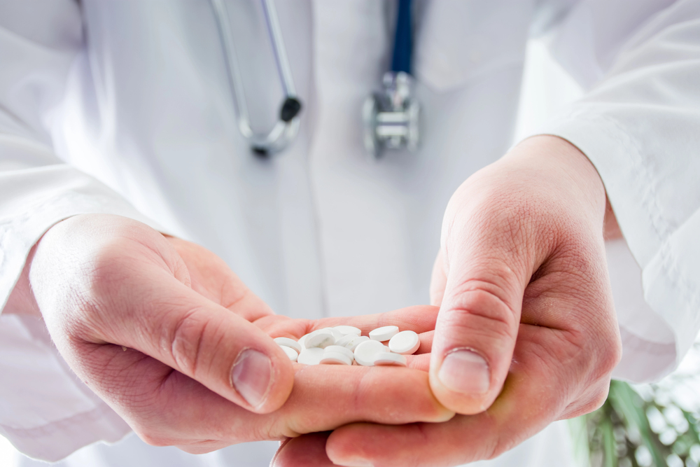 Doctor keeps in folded palms pills